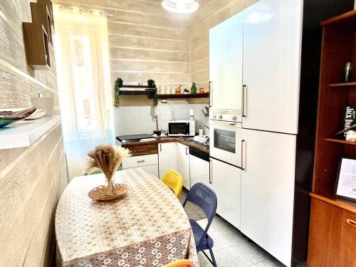 una pequeña cocina con mesa y nevera en ROMUhouse economy apartment METRO B en Roma