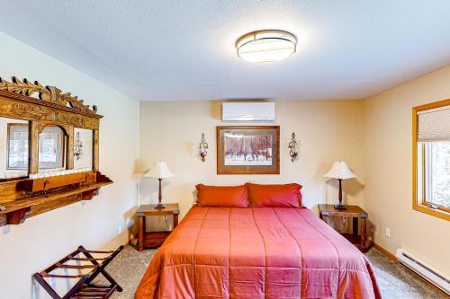 ein Schlafzimmer mit einem Bett, einem Spiegel und 2 Tischen in der Unterkunft Black Hills Hideaway in Lead