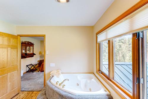 eine große Badewanne in einem Zimmer mit Fenster in der Unterkunft Black Hills Hideaway in Lead