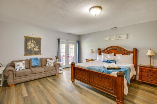 a bedroom with a large bed and a couch at Charming Cadillac Retreat with Private Hot Tub! in Cadillac