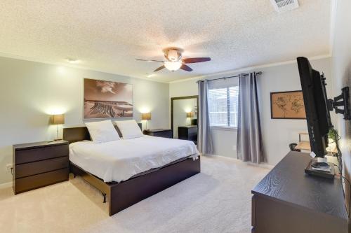 a bedroom with a bed and a flat screen tv at Chic Lewisville Getaway with Private Pool and Hot Tub! in Lewisville
