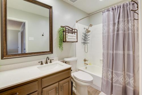 a bathroom with a sink and a toilet and a mirror at Chic Lewisville Getaway with Private Pool and Hot Tub! in Lewisville