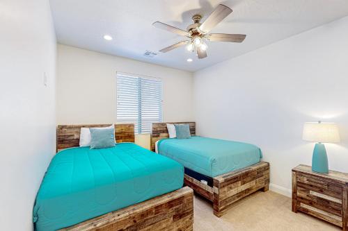 een slaapkamer met twee bedden en een plafondventilator bij Arena Roja House in Washington