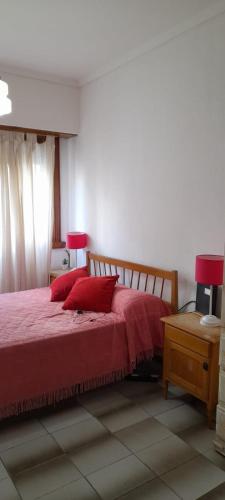 1 dormitorio con 1 cama con sábanas rojas y almohadas rojas en 1 amb zona Plaza Colón en Mar del Plata