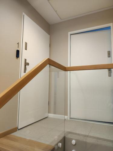an empty room with a large door and a staircase at Sileo Apart No.85 in Ustka