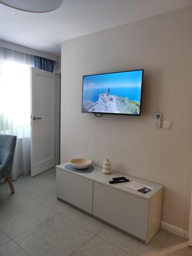 a living room with a flat screen tv on the wall at Sileo Apart No.85 in Ustka