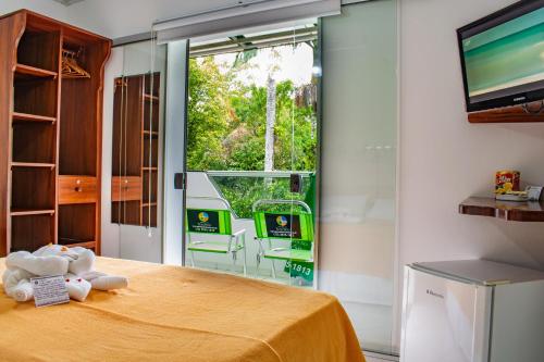 a bedroom with a bed and a large window at Pousada do Tenório in Ubatuba