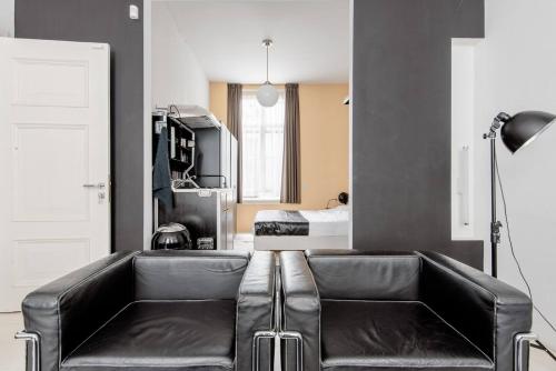 a living room with a leather couch and a bed at Zocher6 BnB a monumental town house in the city center in Utrecht