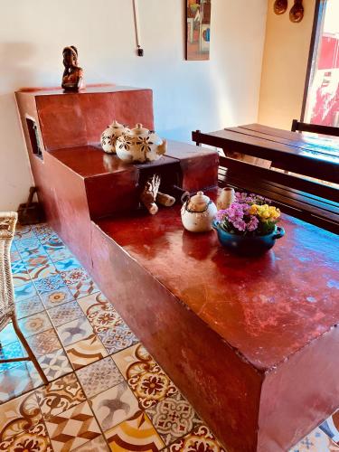 a wooden table with bowls and flowers on top of it at Pousada Jardim do Éden in Serra do Cipo