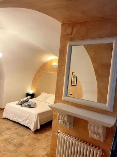 um quarto com uma cama e um espelho na parede em Raffinato Open Space em Orsogna