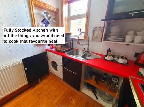 a kitchen with a sink and a washing machine at F1 MAISON 108 - Holiday Home - Full Kitchen - Street FREE PARKING, NETFLIX - 68Mbps BT WIFI - DVD's - Welcome Tray - By Corner from Gavin n Stacey Film House in Barry