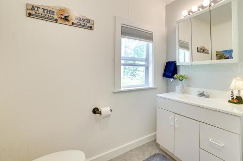 La salle de bains blanche est pourvue de toilettes et d'un lavabo. dans l'établissement Enchanted Lake Huron Cottage with Beach Access!, à Rogers City