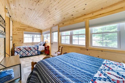 Cette cabane en rondins comprend un lit et des fenêtres. dans l'établissement Enchanted Lake Huron Cottage with Beach Access!, à Rogers City