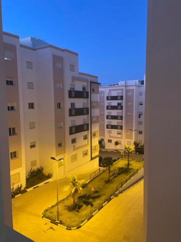 uitzicht op een stad met gebouwen en palmbomen bij Appartement a tanger 7 min de la gare TGV et Malabata En Voiture pour famille, for family , INTERDIT COUPLES ARAABIC NON MARIÉ, FORBIDDEN UNMARRIED ARAABIC COUPLES in Tanger