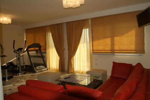 a living room with a red couch and a table at Liberty - Classic luxury sea view villa with private pool, Panoramic views to Kommeno & Corfu old Town in Kommeno