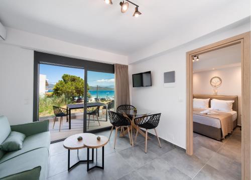 Una sala de estar con una cama, una mesa y sillas. en Blue Icons Lefkas, en Nikiana