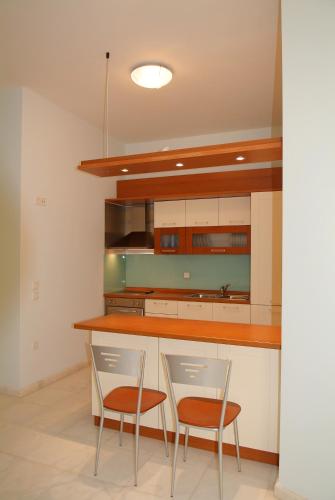 a kitchen with two chairs and a counter at Liberty - Classic luxury sea view villa with private pool, Panoramic views to Kommeno & Corfu old Town in Kommeno