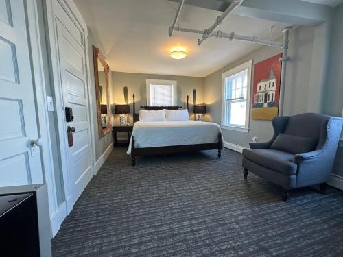 una camera con un letto e una sedia e una finestra di Gifford House a Provincetown
