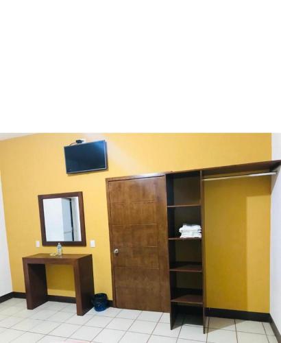 Zimmer mit einem Schrank, einem Spiegel und einer Tür in der Unterkunft Hospedaje Familiar in Tequila