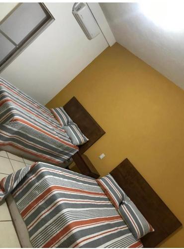 2 Betten mit gestreiften Kissen in einem Zimmer in der Unterkunft Hospedaje Familiar in Tequila