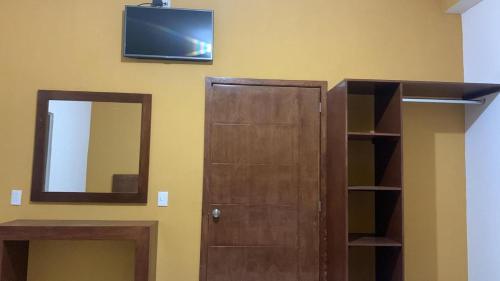 eine Tür mit einem Spiegel und einem TV an der Wand in der Unterkunft Hospedaje Familiar in Tequila