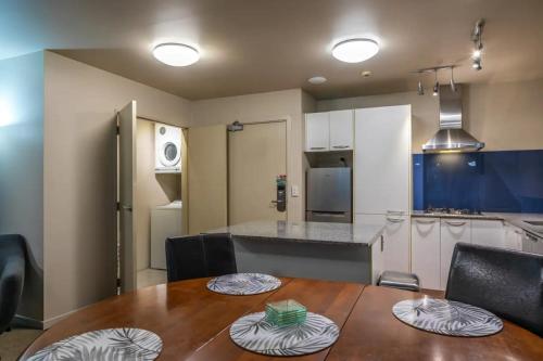 a kitchen with a wooden table and a kitchen with a counter at The Glebe Apartments in Queenstown