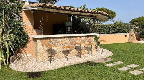 a group of stools sitting on a stone wall at Antica Fonte Holiday Homes in San Pantaleo