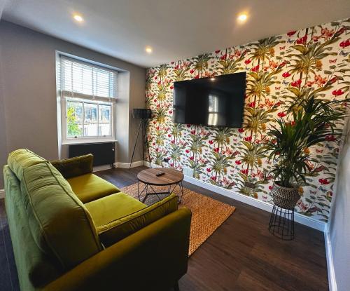 鲍内斯温德米尔1 West End Boutique Apartment的客厅里有一张沙发，墙上有一台电视