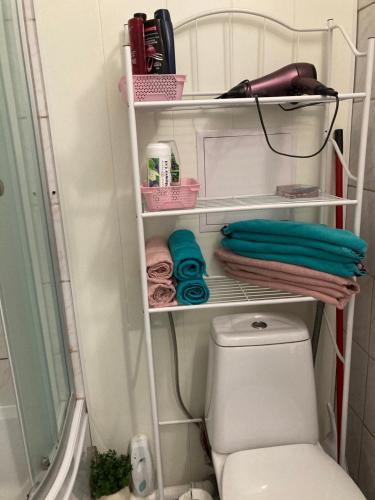 a bathroom with a toilet and towels and a shower at Karja 5 Apartment in Narva-Jõesuu