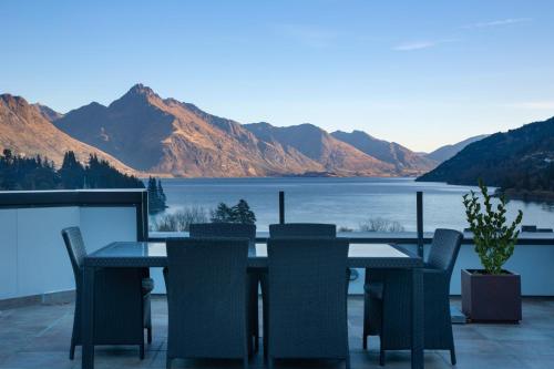 a table and chairs with a view of a lake at The Glebe Apartments in Queenstown