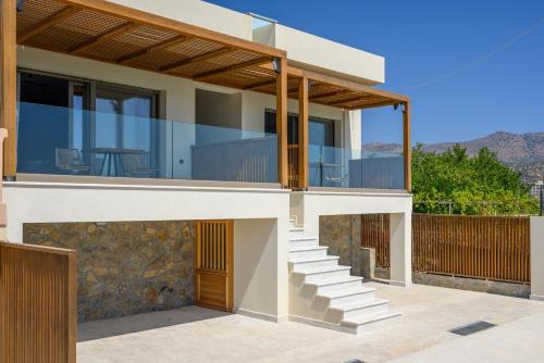 a house with glass walls and a balcony at Amare Studios in Agios Nikolaos