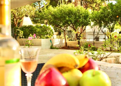 Villa Naya by the Beach في أنافيسوس: وعاء من الفاكهة وكأس من النبيذ