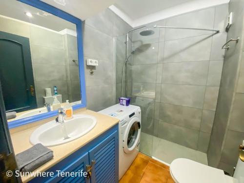 Un baño con lavabo y lavadora. en Spacious apartment with private garden in Tenerife south, en San Miguel de Abona