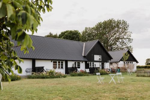 a black and white house with chairs in the yard at Sköllengården in Simrishamn