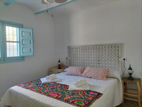 ein Schlafzimmer mit einem Bett mit zwei Hüten darauf in der Unterkunft La casa de tío Vidal in Pedro Bernardo