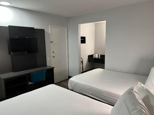 um quarto de hotel com duas camas e uma televisão de ecrã plano em Motel 6-Lakeland, FL em Lakeland