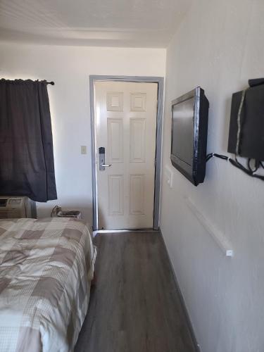 a bedroom with a bed and a flat screen tv at Nights Inn Motel in Oakland