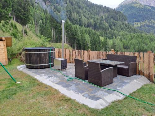 a patio with a table and chairs and a hot tub at Siegel Almhütte in Zederhaus
