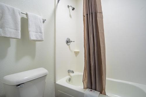a bathroom with a toilet and a shower with towels at Motel 6 Manchester TN in Manchester