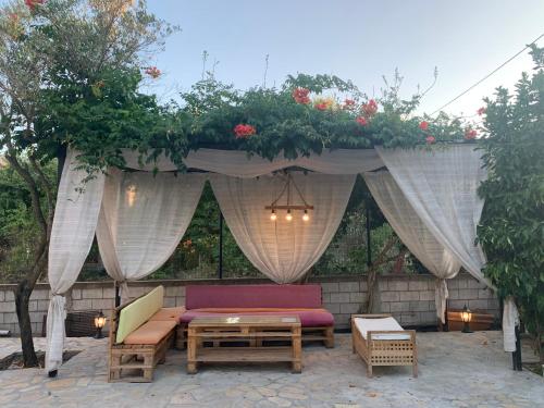 a patio with a couch and a table under a canopy at VILLA KATERINA Nea Vrasna in Nea Vrasna