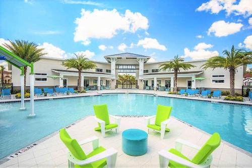 a swimming pool with chairs and a building at 4 bedrooms pool home gated resort of Veranda Palms in Kissimmee