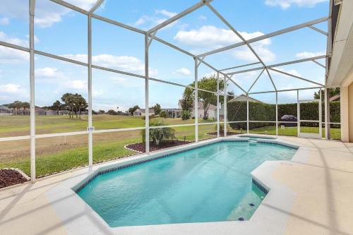 a swimming pool in a building with a large window at 4 bedrooms pool and spa home on golf course Fairways Estates in Kissimmee