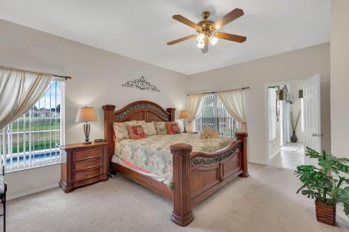 a bedroom with a bed and a ceiling fan at 4 bedrooms pool and spa home on golf course Fairways Estates in Kissimmee
