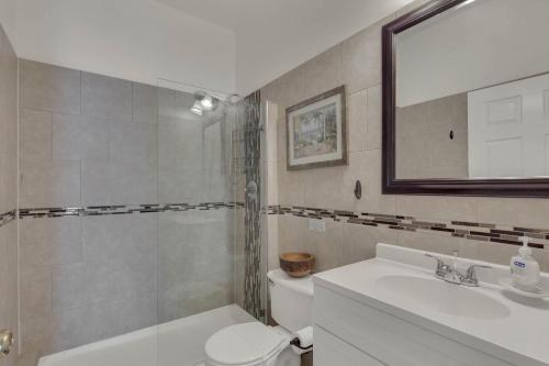 a bathroom with a sink and a toilet and a mirror at 4 bedrooms pool and spa home on golf course Fairways Estates in Kissimmee