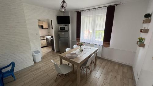 a kitchen and dining room with a table and chairs at Pokoje u Lusi in Tylicz