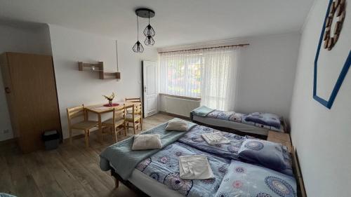 ティリチにあるPokoje u Lusiの小さなベッドルーム(ベッド2台、テーブル付)
