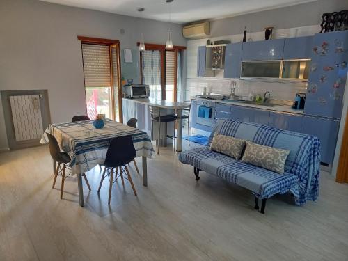 cocina y sala de estar con sofá y mesa en Casa Vacanze Salerno LA RONDINE, en San Mango Piemonte