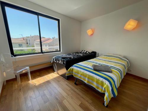 une chambre avec un lit et une grande fenêtre dans l'établissement UNIQUE! APPART TOIT TERRASSE - 100m MER, à Marseille
