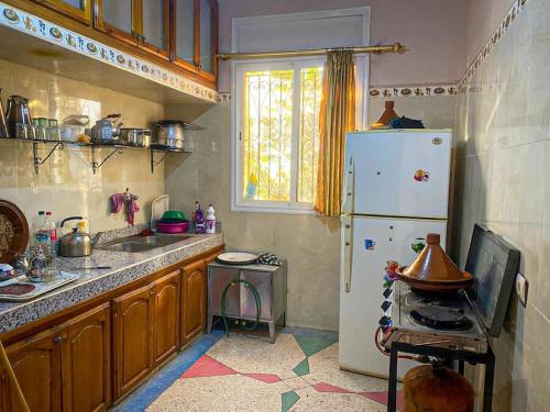 a kitchen with a white refrigerator and a sink at استمتع بالإقامة في فيلا أحلامك in El Khemis des Meskala