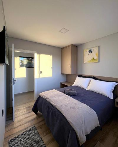 a bedroom with a large bed with a blue blanket at Apartamento La Vie in São Joaquim